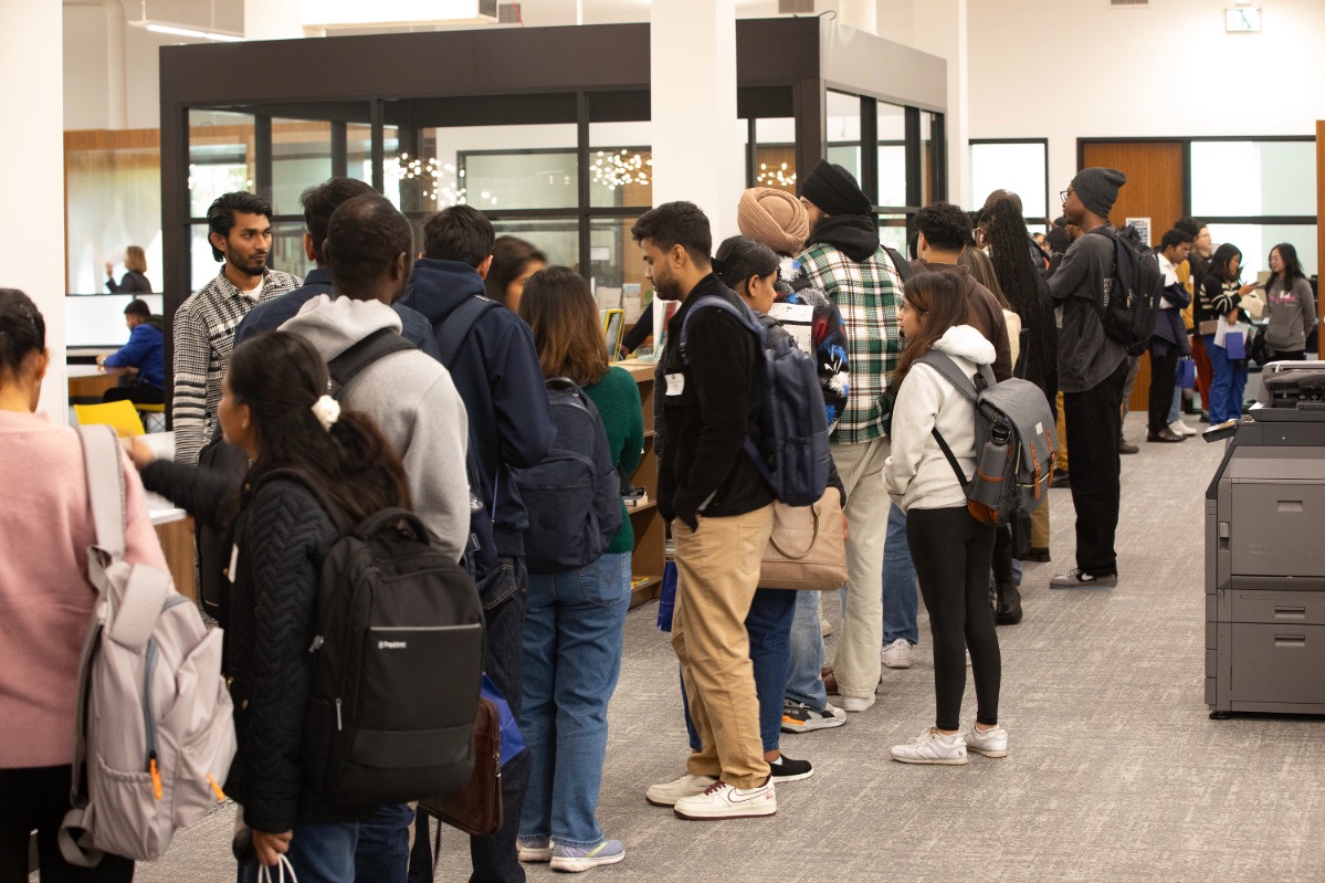 New students are asking questions to the staff on orientation day.