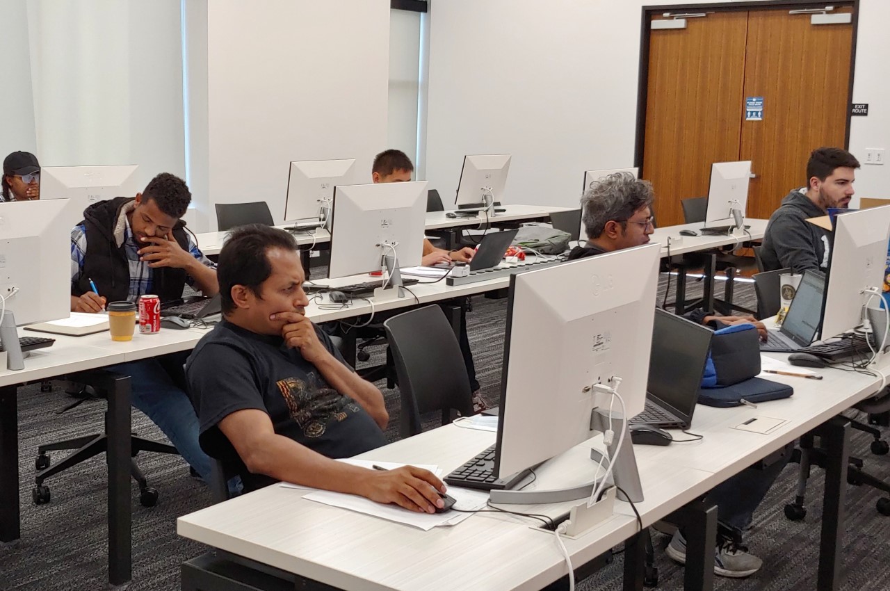 A group of students is using the computers in the lab room.