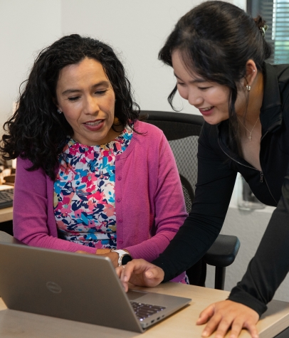 Two females looking over laptop collaborating