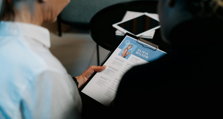 Woman Holding a Clipboard with Resume