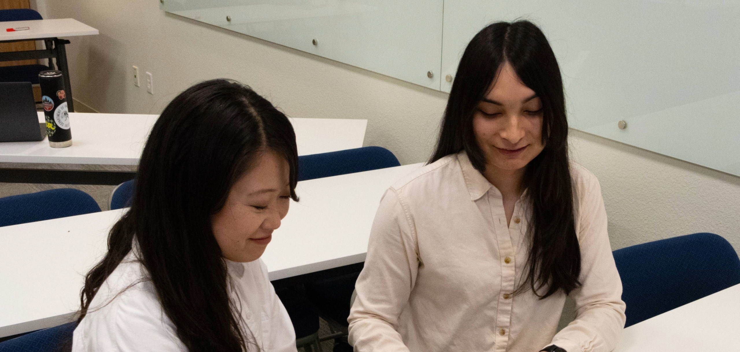 Two Student Support Specialists are talking in the classroom with the smiles