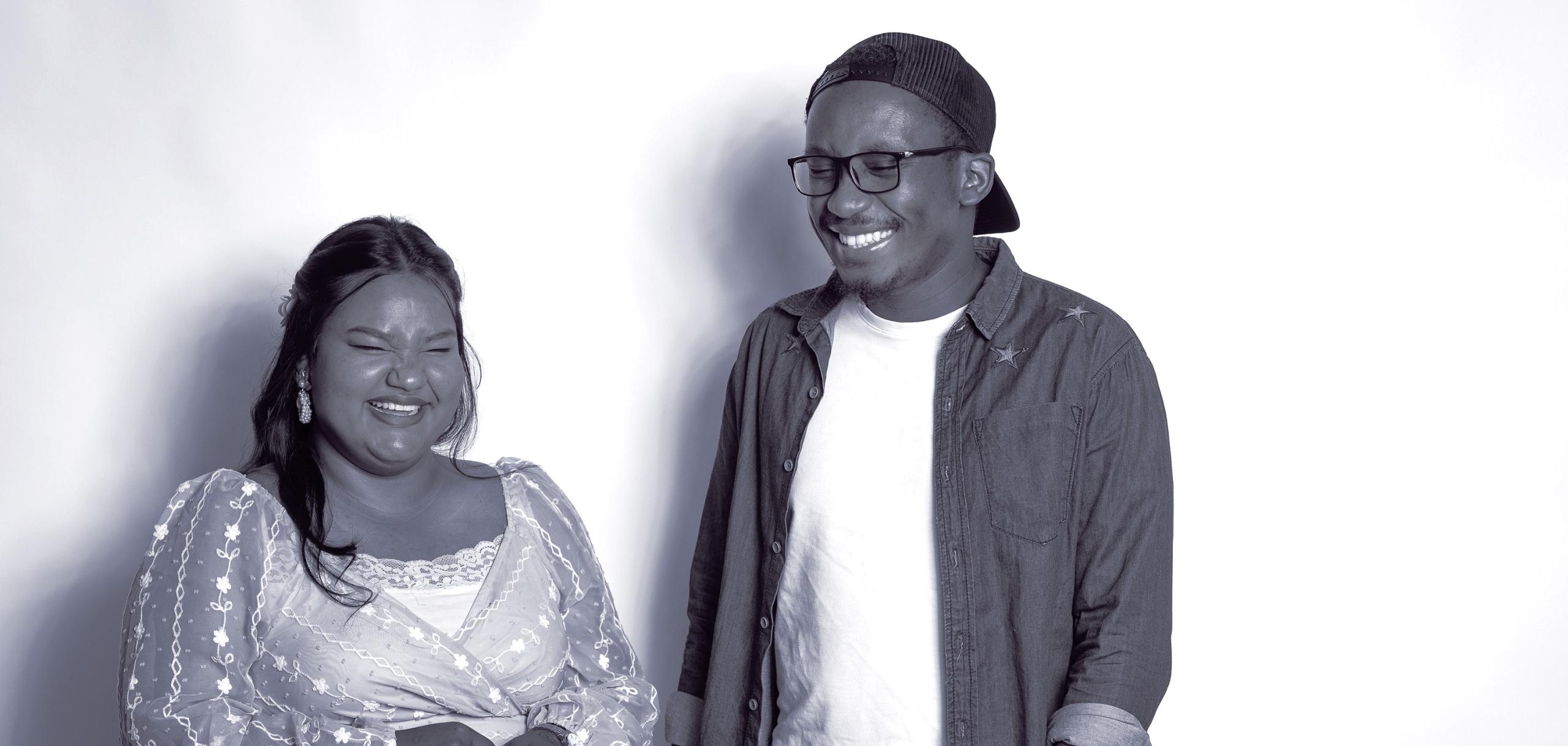 Two students against white backdrop, smiling