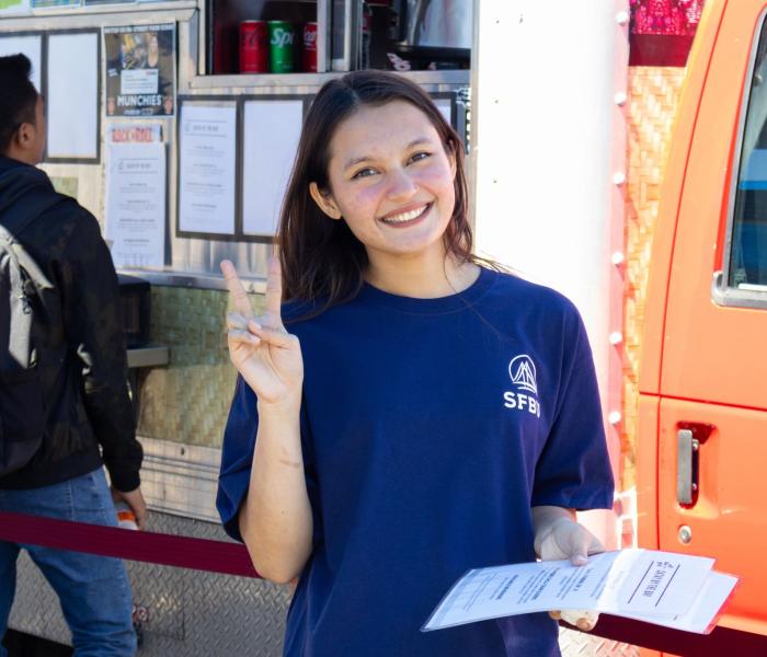 student giving peace sign