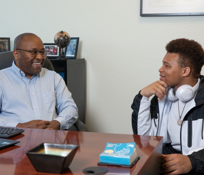 Dr. Peter Maribei is talking with a student in the Student Success Hub