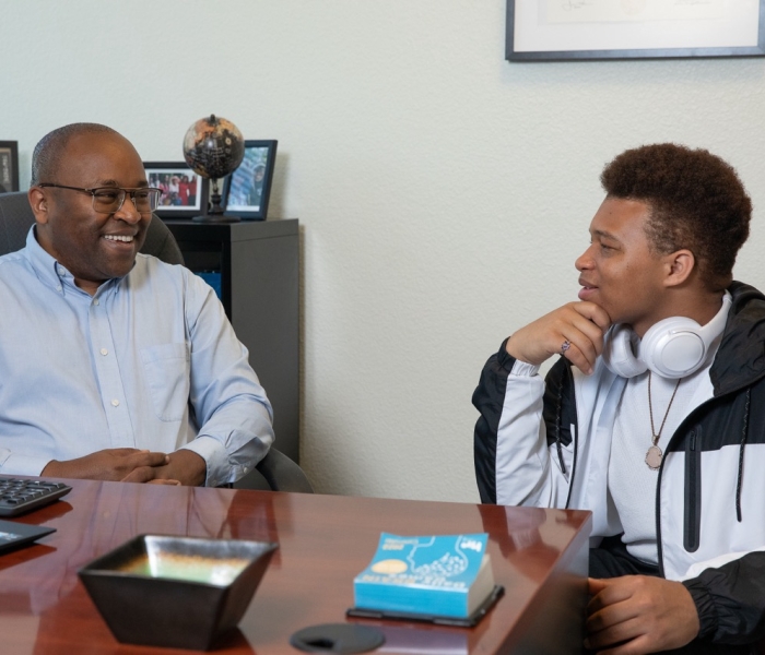 Dr. Peter Maribei is talking with a student in the Student Success Hub