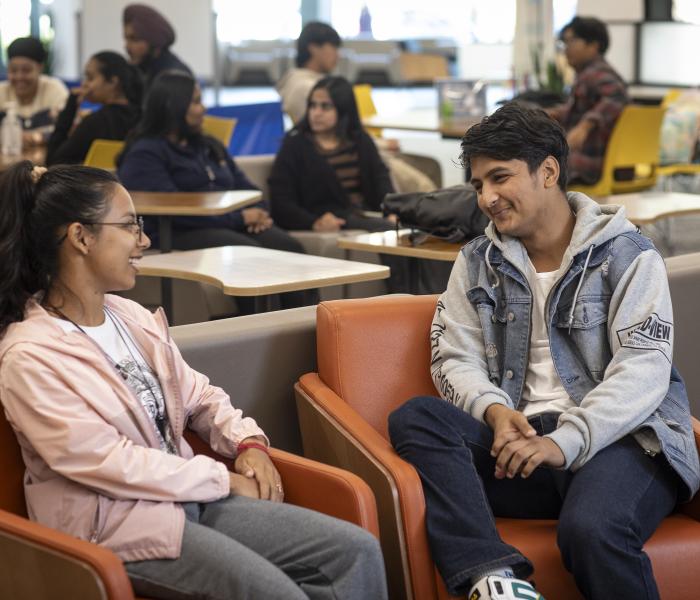 Two students chatting in lounge chairs