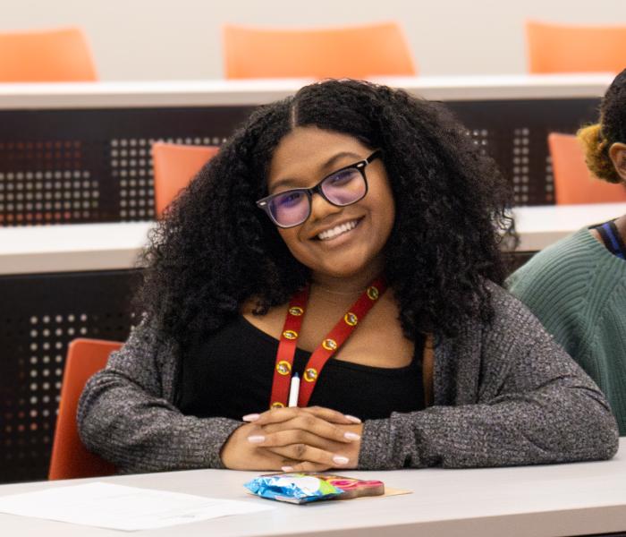 Student smiling at desk