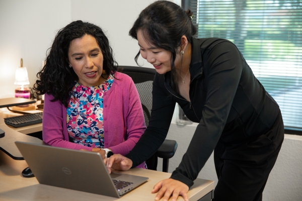 Two females looking over laptop collaborating