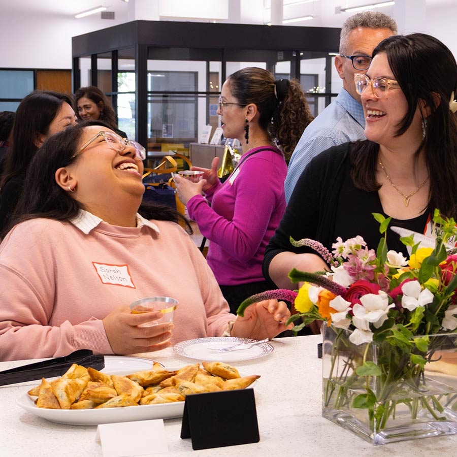 Two female staff members laughing